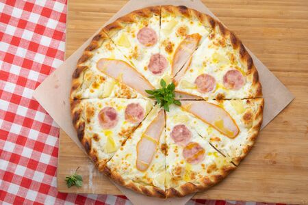 Pizza with chicken and ham close-up with various ingredients decorated with Basil, an assortment of traditional Italian fast foodsの写真素材