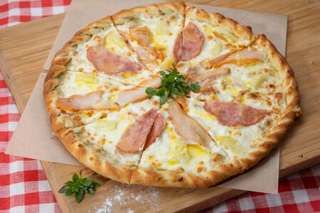 Pizza with different sausages close-up with different ingredients decorated with Basil, an assortment of traditional Italian fast foodsの写真素材