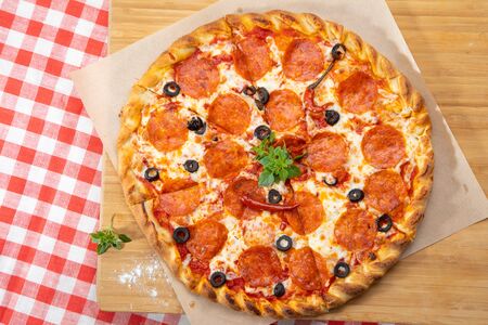 Pepperoni pizza close-up with various ingredients decorated with Basil, an assortment of traditional Italian fast foodの写真素材