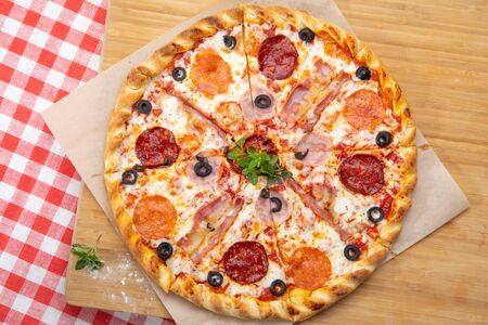 Pizza with different sausages close-up with different ingredients decorated with Basil, an assortment of traditional Italian fast foodsの写真素材