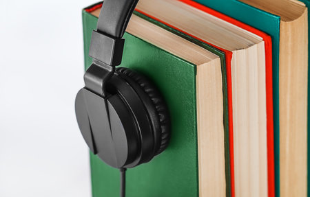 Books and headphones on white background, closeup. Audio book conceptの写真素材