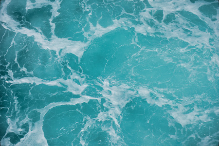 Abstract blue sea water with white foam for backgroundの写真素材