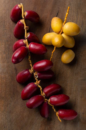 fresh yellow and red dates on wooden backgroundの写真素材