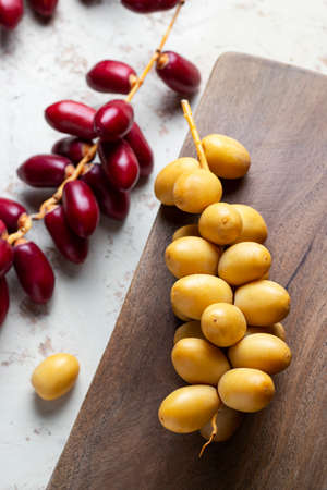 fresh yellow and red dates on wooden background