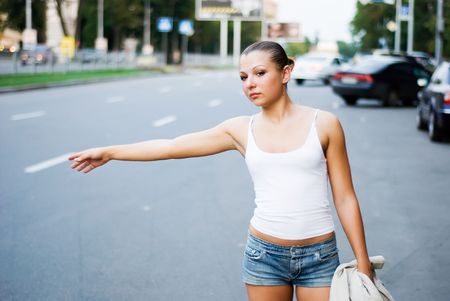 young woman trying to get a taxiの写真素材