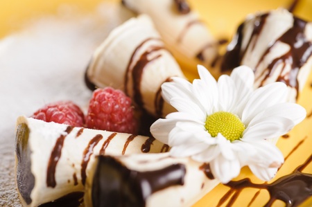 Piece of cake on plate with berries and fruits and camomileの写真素材