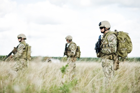 Soldiers  in full gear patrol the area in the desertの写真素材