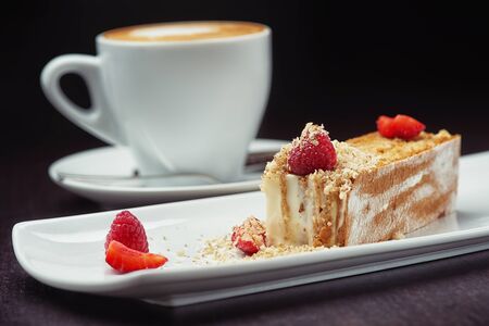 Beautiful cake dessert with coffee cream and fresh berry on black backgroundの写真素材