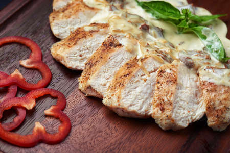 Appetizing baked pieces of pork in mushroom sauce with cream on deskの写真素材