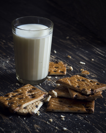Milk and Cookies on a dark wood backgroundの写真素材