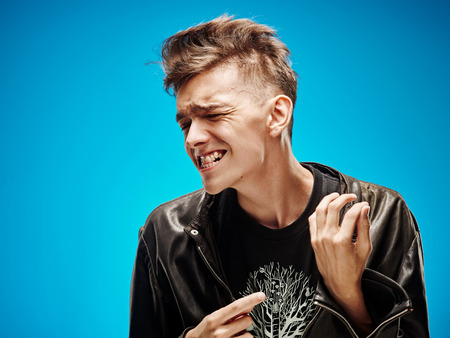 Emotional portrait of a teenager on a blue background
