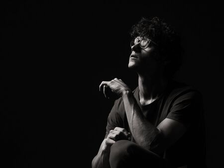 Emotional black and white dramatic portrait of a pretty young manの写真素材