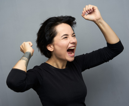 Emotional portrait of female with cheerful expression, dressed in casual clothes,の写真素材