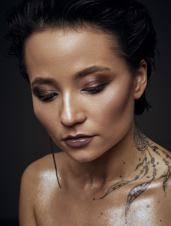 woman with tattoo beauty studio portrait on a rustic backgriundの写真素材
