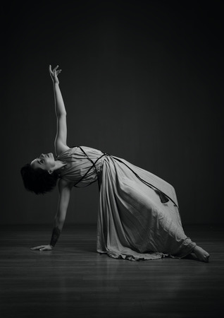 black and white dancing woman studio portrait on a dark background