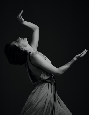 black and white dancing woman studio portrait on a dark backgroundの写真素材