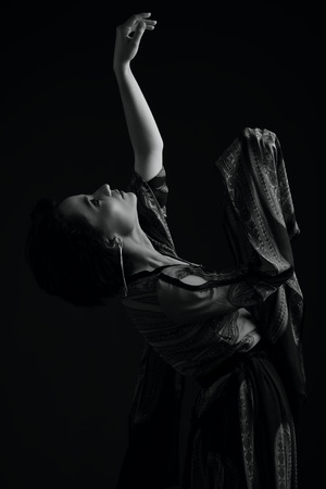 black and white dancing woman studio portrait on a dark backgroundの写真素材