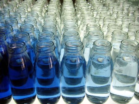 Milk Bottle Line-Up -- filled with various shades of blue liquidの写真素材
