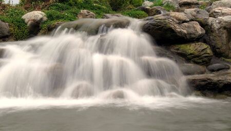 Park scene with rocks and cascading waterの写真素材