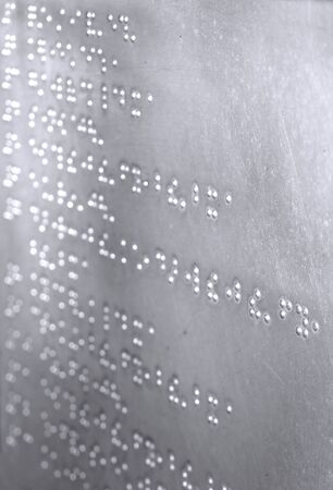 A metal sheet with Braille writing imprinted on itの写真素材