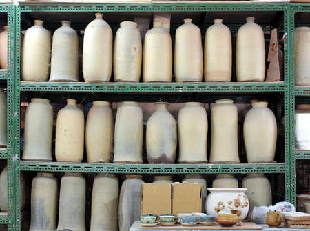 Unfinished ceramic vases are arranged on shelves in a pottery studioのeditorial素材