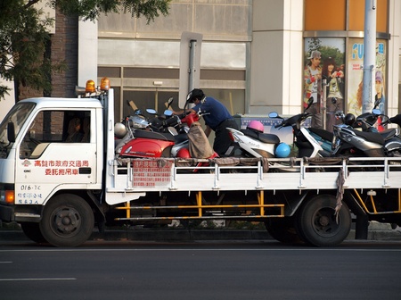 KAOHSIUNG, TAIWAN - DECEMBER 28: Police enforce new traffic rules and tow away illegally parked scooters on December 28, 2011 in Kaohsiungのeditorial素材