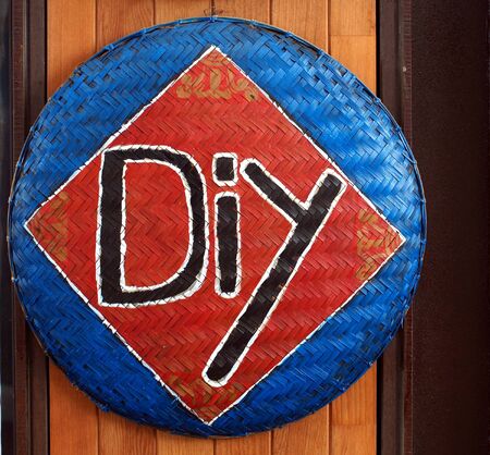 A hand-painted sign with the letters DIY on hand-made basketのeditorial素材