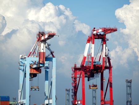 Close view of two large gantry cranes used to load shipping containersの写真素材