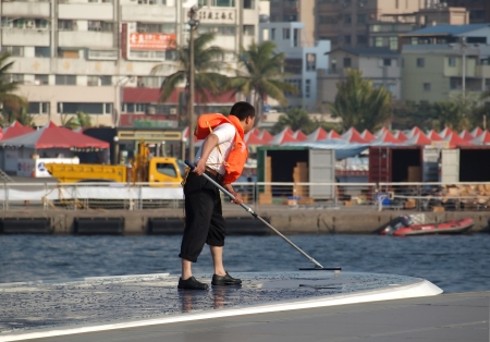 KAOHSIUNG, TAIWAN - FEBRUARY 22: An unidentified crew member washes the solar panelled roof of a sightseeing boat on the Love River on February 22, 2013 in Kaohsiung.のeditorial素材