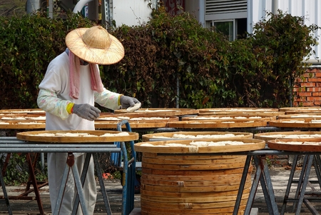 TAINAN, TAIWAN -- MARCH 4, 2014: An unidentified worker checks on noodles that are dried in the sun before packaging, a local specialty in southwest Taiwan.のeditorial素材