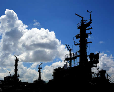 Outlines of tugboats against a blue summer skyの写真素材