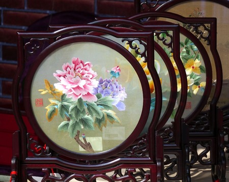 KAOHSIUNG, TAIWAN -- JANUARY 1, 2015: An outdoor vendor sells embroidered silk screens in wood framing, a popular Chinese art and craft product.のeditorial素材