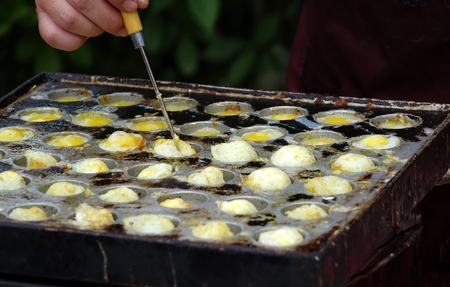 A street vendor cooks poached quail eggs, a popular snack in Taiwanの写真素材