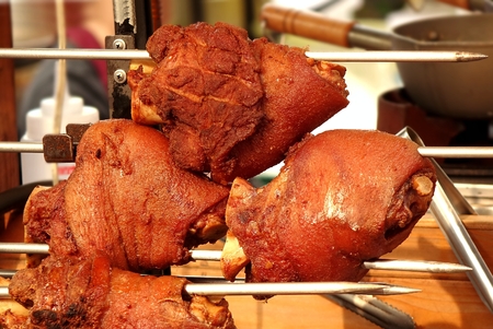 An outdoor vendor sells grilled pork knuckles or ham hockの写真素材