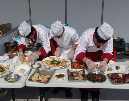 KAOHSIUNG, TAIWAN -- NOVEMBER 28, 2015: Three chefs prepare dishes for the cooking competition during the 2015 Hakka Food Festival, which is a yearly public outdoor event.のeditorial素材