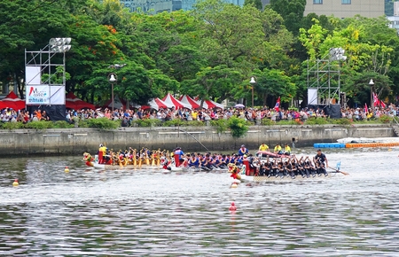KAOHSIUNG, TAIWAN -- JUNE 9, 2016: Three unidentified teams compete in boat races on the Love River during Dragon Boat Festival.のeditorial素材