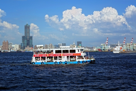 KAOHSIUNG, TAIWAN -- JULY 4, 2016: The Kaohsiung harbor ferry makes its way to the island of Chijin. In the back is the skyline of the city.のeditorial素材