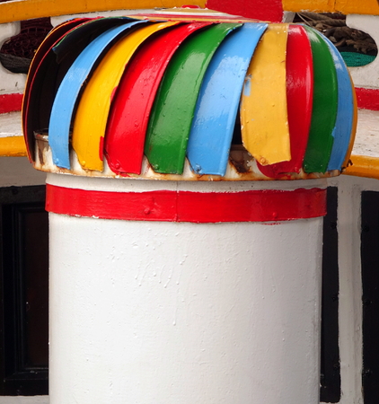A colorful exhaust vent on a local fishing boatの写真素材