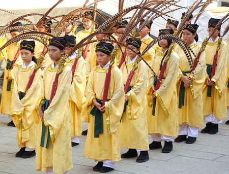 KAOHSIUNG, TAIWAN -- SEPTEMBER 28 , 2017: Young students in yellow robes carry peacock feathers during the yearly Confucius Ceremony held on Teachers Day.のeditorial素材