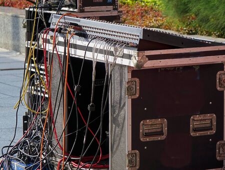 A large audio mixer console with a multitude of cables attached
の写真素材