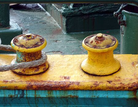 Two old mooring posts with a thick rope wrapped around itの写真素材