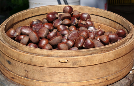 A vendor sells chestnuts cooked in a bamboo steamerの写真素材