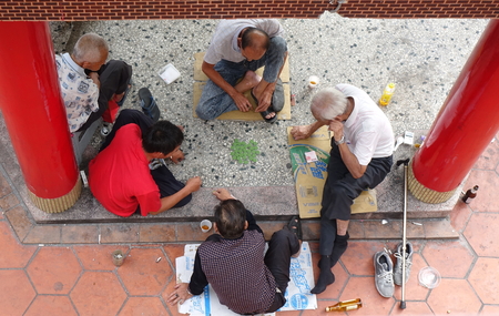 KAOHSIUNG, TAIWAN -- OCTOBER 19, 2018: Four elderly men play checkers under the roof of a local temple.のeditorial素材