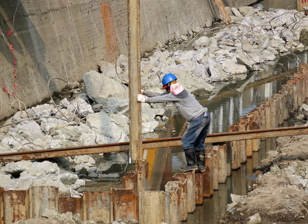 KAOHSIUNG, TAIWAN -- OCTOBER 10, 2018: A construction worker guides the placement of a steel girder to be driven into the ground by a pile driver.のeditorial素材
