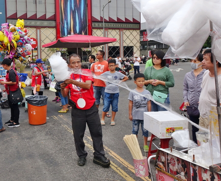 KAOHSIUNG, TAIWAN -- DECEMBER 8, 2018: A street vendor demonstrate his skills at making cotton candy at a local outdoor event.のeditorial素材