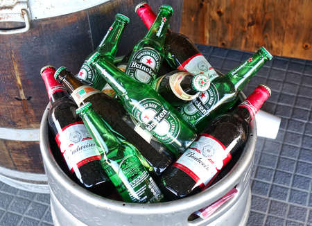 KAOHSIUNG, TAIWAN -- JUNE 2, 2019: A food stall prepares beer bottles in an aluminum barrel.のeditorial素材