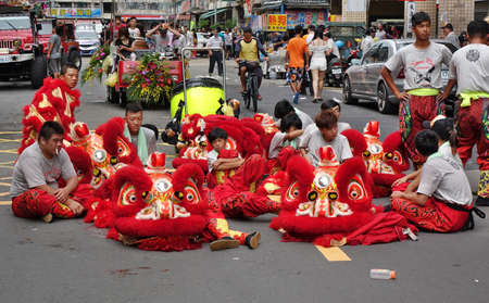 KAOHSIUNG, TAIWAN -- JULY 9, 2016: Male lion dancers are resting between performances during a traditional religious temple ceremony.のeditorial素材