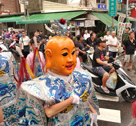 KAOHSIUNG, TAIWAN -- JULY 9, 2016: Male dancers with head covering masks perform during a traditional religious temple ceremony.のeditorial素材