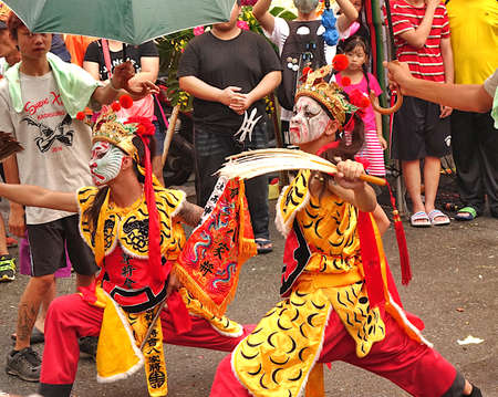 KAOHSIUNG, TAIWAN -- JULY 9, 2016: Male dancers with face painted masks perform during a traditional religious temple ceremony.のeditorial素材