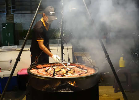 KAOHSIUNG, TAIWAN -- MARCH 2, 2018: An outdoor vendor at a night market grills fresh pork sausages and meat.のeditorial素材